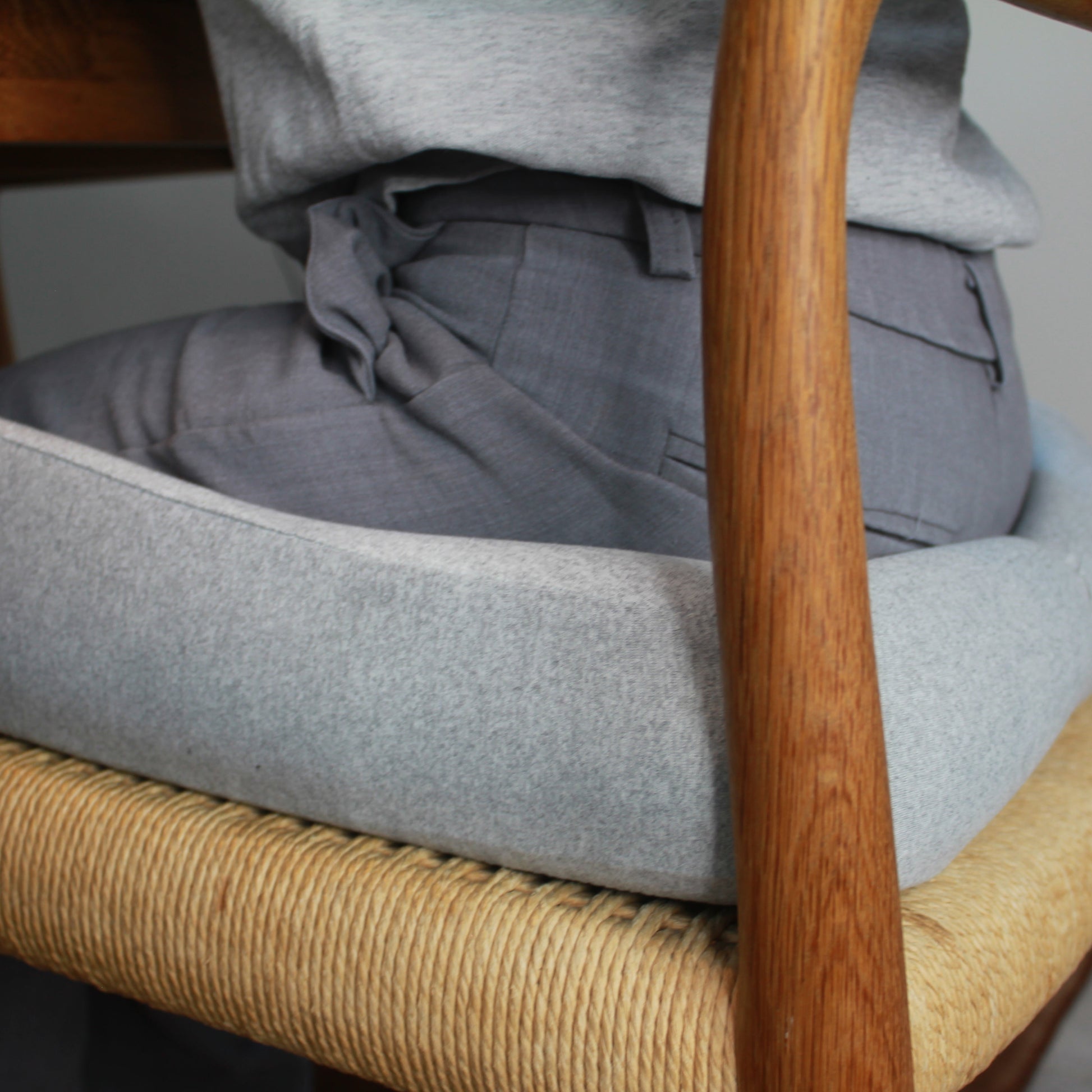 Ergonomisk memory foam siddepude i grå på spisebordsstol med træarmlæn. Aflaster ryg og hofter ved stillesiddende arbejde. Copenhagen Comfort.