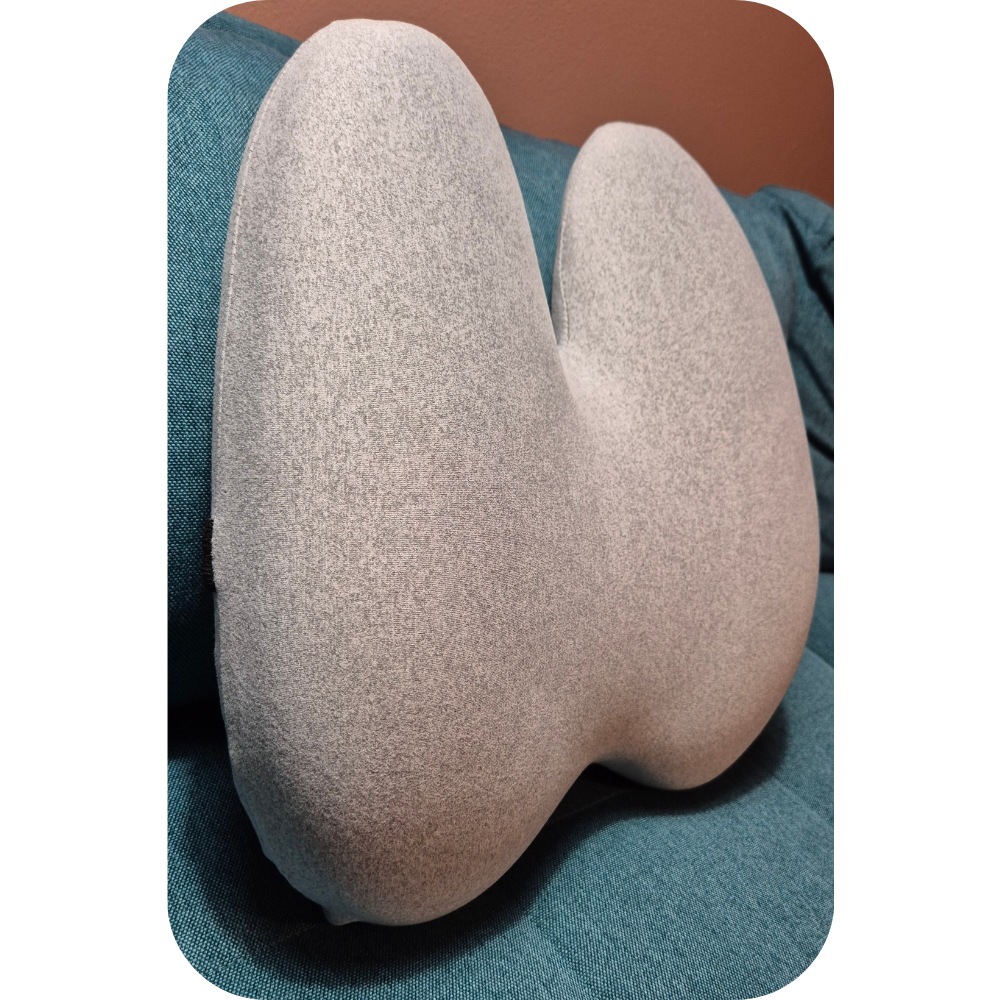 Memory foam rygpude i grå, vist på sofa. Ergonomisk design, der støtter lænd og ryg ved afslapning i hjemmet.