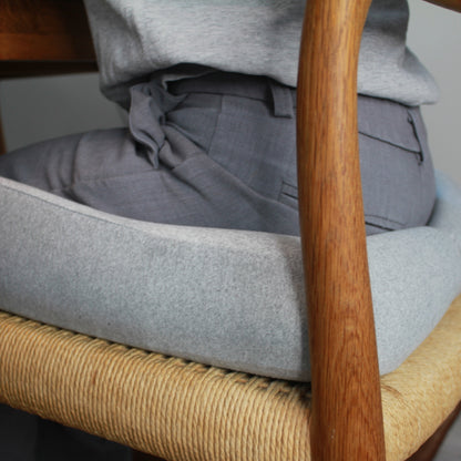 Ergonomisk memory foam siddepude i grå på spisebordsstol med træarmlæn. Aflaster ryg og hofter ved stillesiddende arbejde. Copenhagen Comfort.