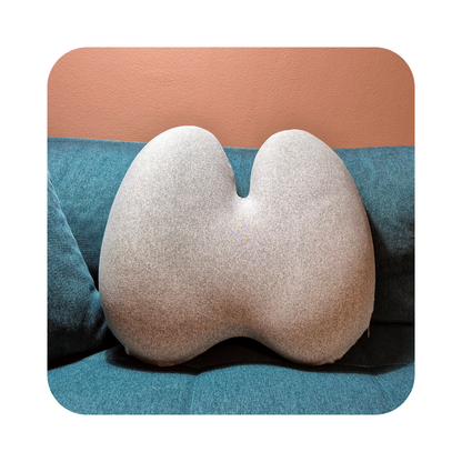 Copenhagen Comfort memory foam rygpude i grå, placeret i sofa. Komfortabel støtte til ryg og nakke under daglig brug.
